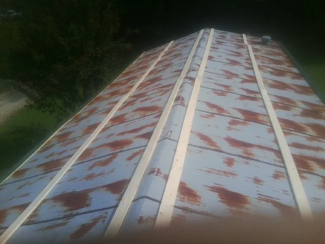 Rusted metal roof panels with new wood purlins before replacement — Storm Damage Roof Repair in Atalissa by Roofing Brothers